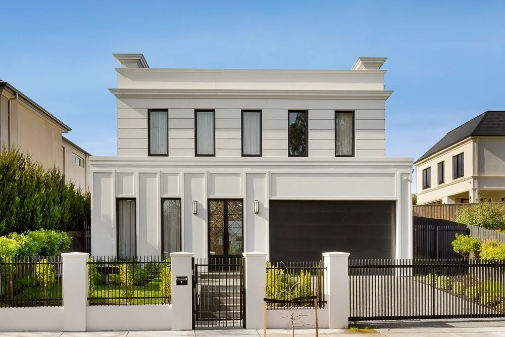 White front façade of the completed Camberwell Residence II with black-framed windows, dark garage door and black fencing